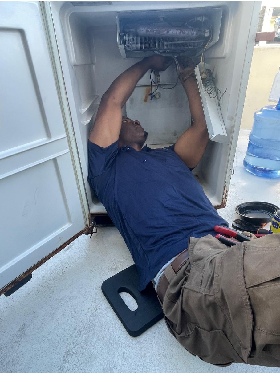 Technician replacing an evaporator inside a fridge